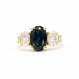 large oval sapphire and diamond engagement ring on white background