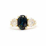 large oval sapphire and diamond engagement ring on white background