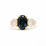 large oval sapphire and diamond engagement ring on white background