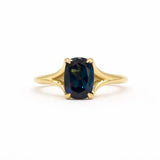 blue sapphire engagement ring with split shank on a white background