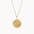 Gold necklace with a round compass pendant on a white background