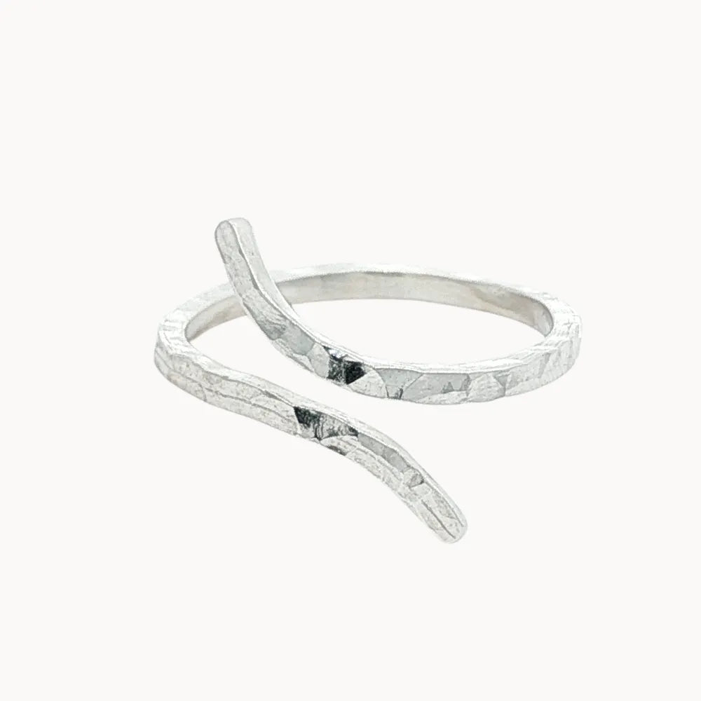 silver hammered ring with unique open shape on a white background