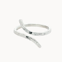 silver hammered ring with unique open shape on a white background