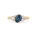 tilted blue sapphire asymmetric engagement ring on a white background with diamonds