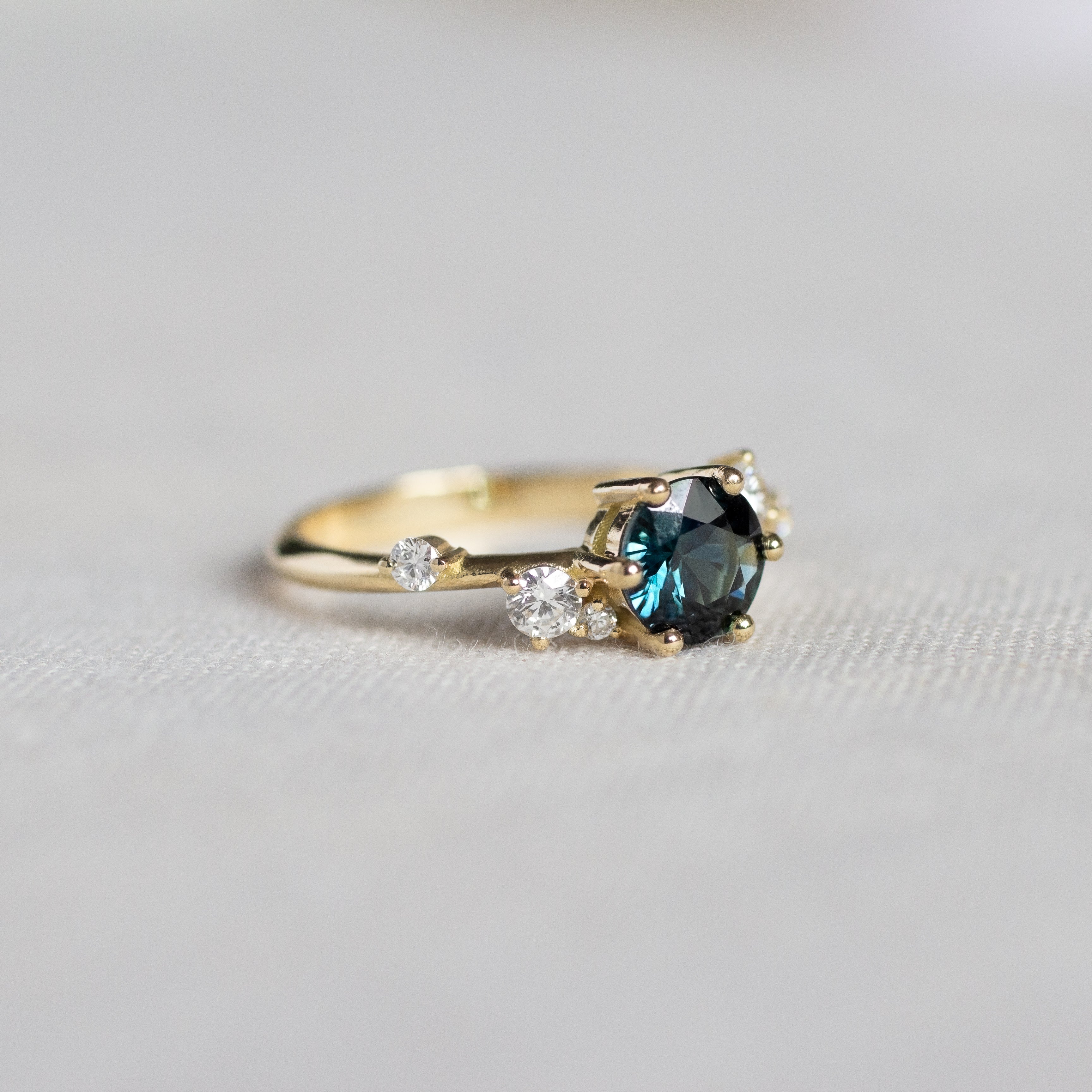 Asymmetrical Round Blue Sapphire Engagement Ring with Sprinkled Diamonds