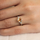 close up of hand wearing a orange sapphire engagement ring with lab grown diamonds