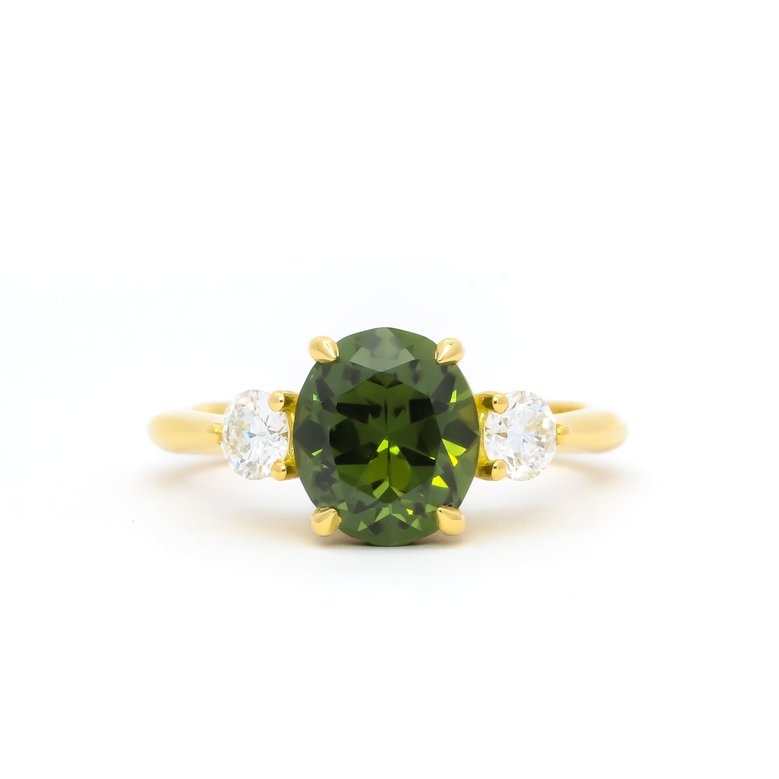 large yellow gold rounded oval green sapphire engagement ring with diamonds on a white background