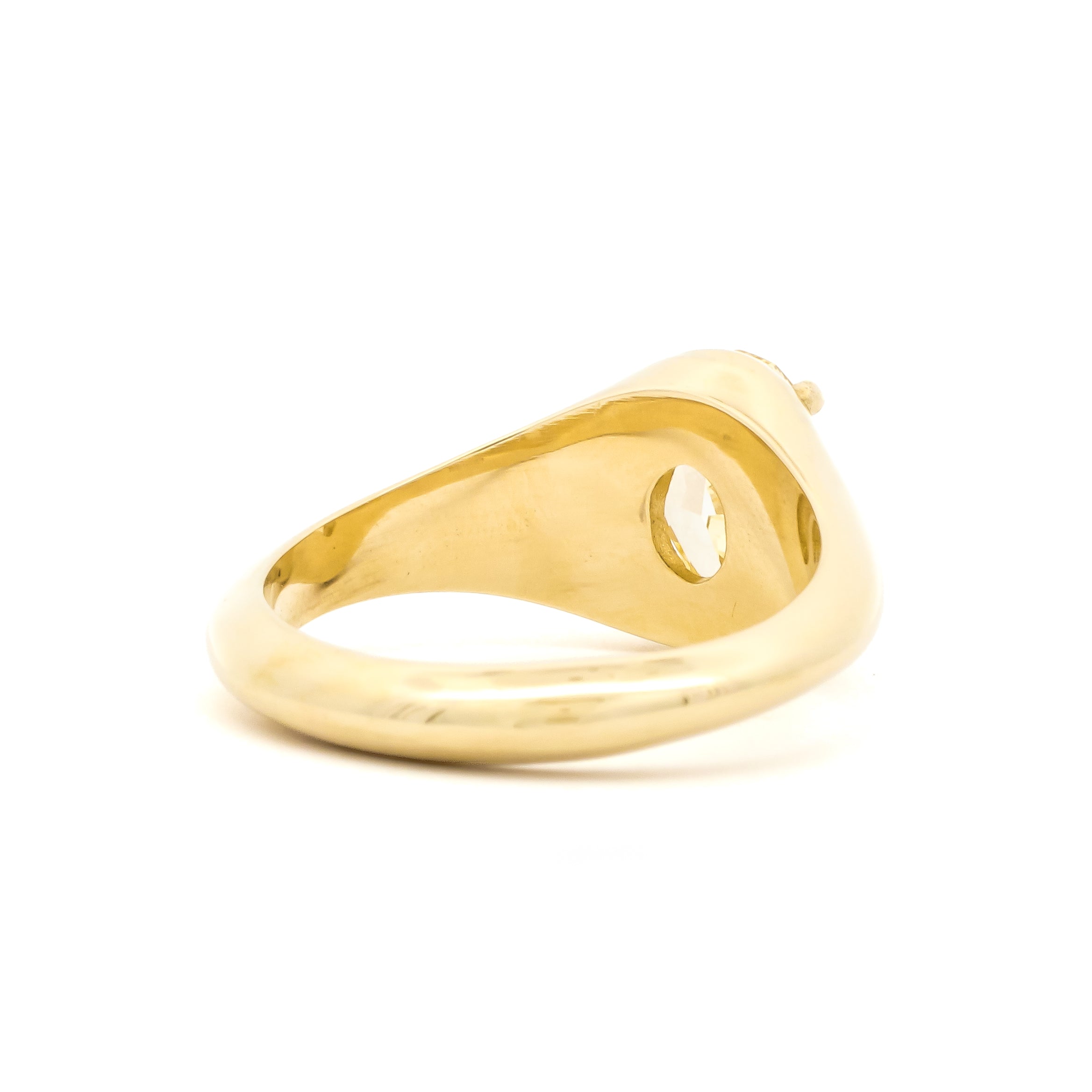 A polished yellow gold signet ring with a yellow diamond, shown from a back view on a white background.