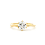 round solitaire diamond engagement ring with 6 round prongs, with wavy molten yellow gold band against a white background