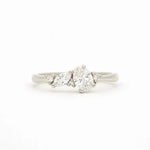 A white gold cluser diamond ring featuring a central brilliant-cut oval diamond flanked by marquise and round diamonds on a clean white background.