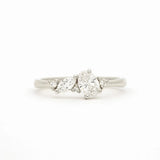 A white gold cluser diamond ring featuring a central brilliant-cut oval diamond flanked by marquise and round diamonds on a clean white background.
