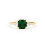 cushion cut green sapphire gold engagement ring with triangle shaped accent diamonds on a white background