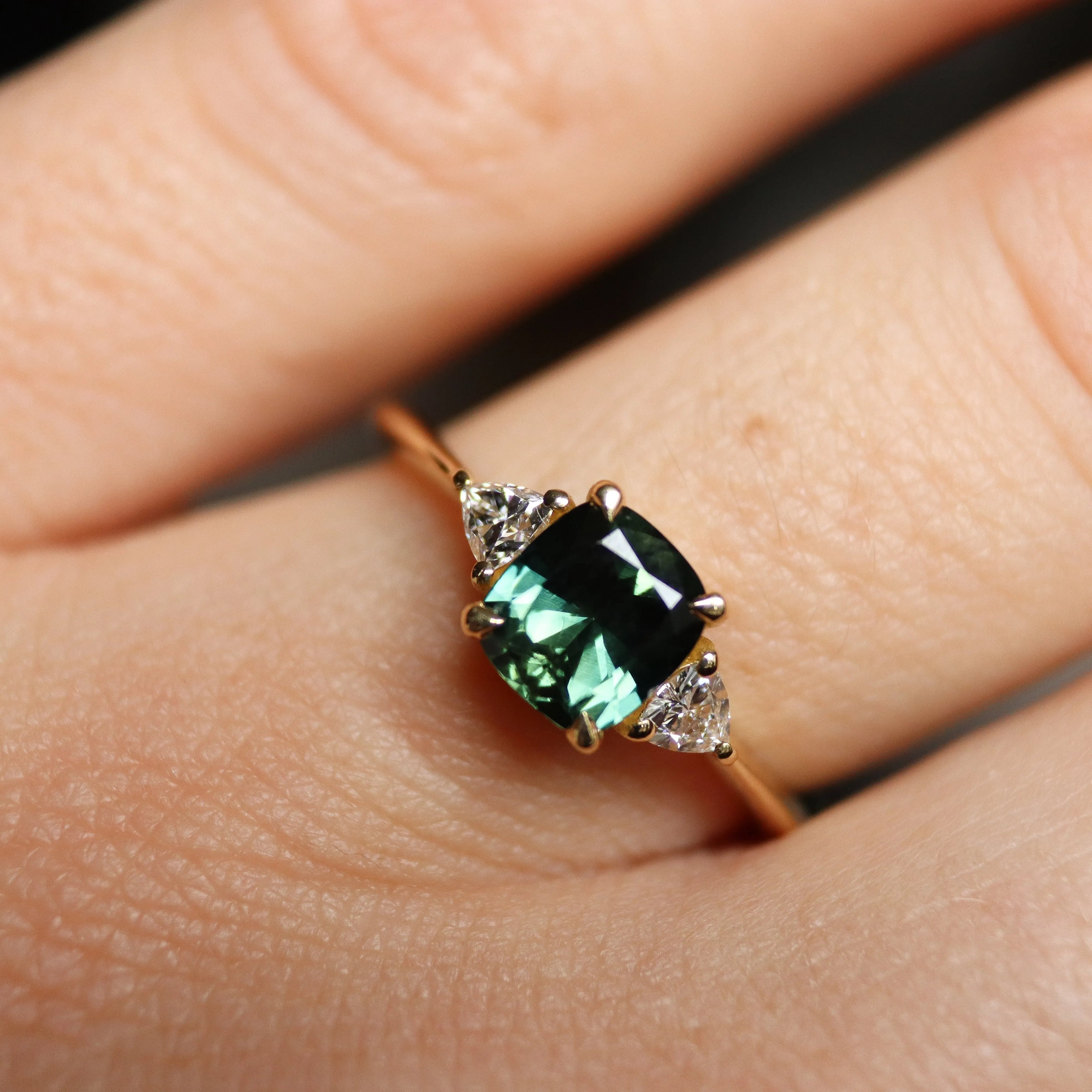cushion cut green sapphire engagement ring on hand