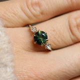 round green sapphire ring with kite diamonds close up on finger