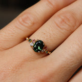 green and pink engagement ring on hand
