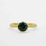 blue/green sapphire engagement ring with gold twisted shank on white background