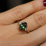 green trilogy engagement ring on hand