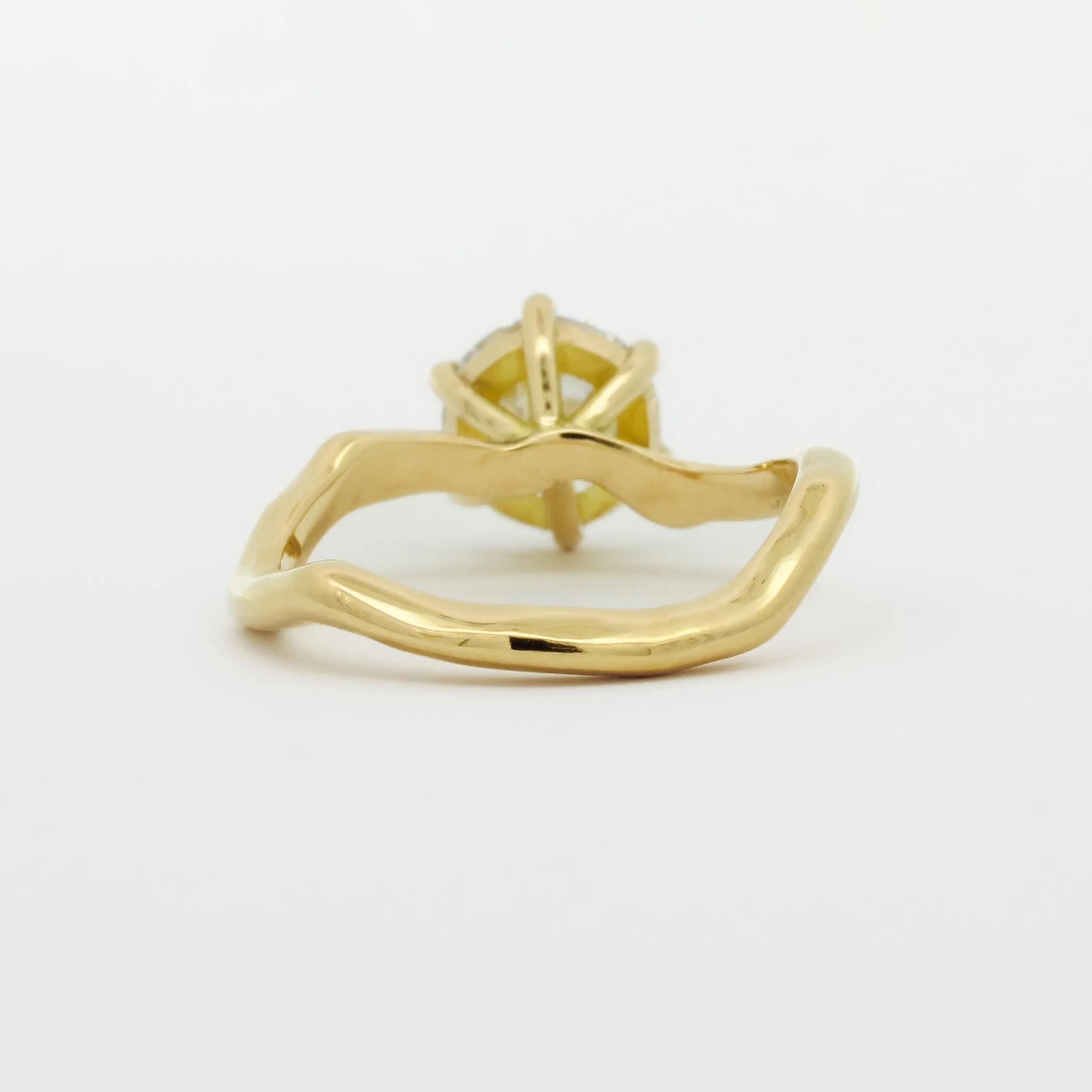 back view of engagement ring with wavy design on a white background