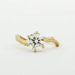 Gold ring with a diamond on a white background