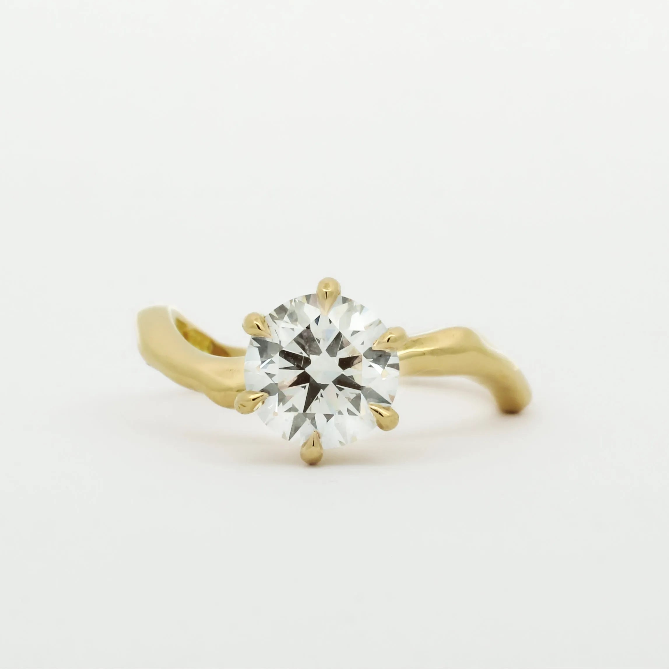 Gold ring with a diamond on a white background