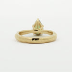 back view of a pear green sapphire engagement ring with textured band