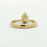 back view of a pear green sapphire engagement ring with textured band
