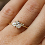 close up of hand wearing a diamond oval and marquise engagement ring