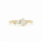 Gold engagement ring with small diamond cluster on a white background