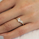 close up of hand wearing a yellow gold and diamond cluster engagement ring