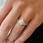 hand wearing large pear diamond engagement ring with leaves 