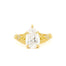 gold engagement ring with pear diamond and leaves on a white background