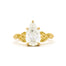 gold engagement ring with leaf detail on band and large pear diamond on a white background
