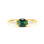 engagement ring with landscape east-west blue/green parti sapphire and diamonds on a white background