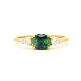 engagement ring with landscape east-west blue/green parti sapphire and diamonds on a white background