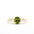 gold engagement ring with a green oval sapphire and four diamonds in tapered composition on a white background