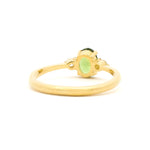 Gold ring with a green gemstone on a white background