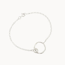 Silver bracelet with a unique ring design on a white background