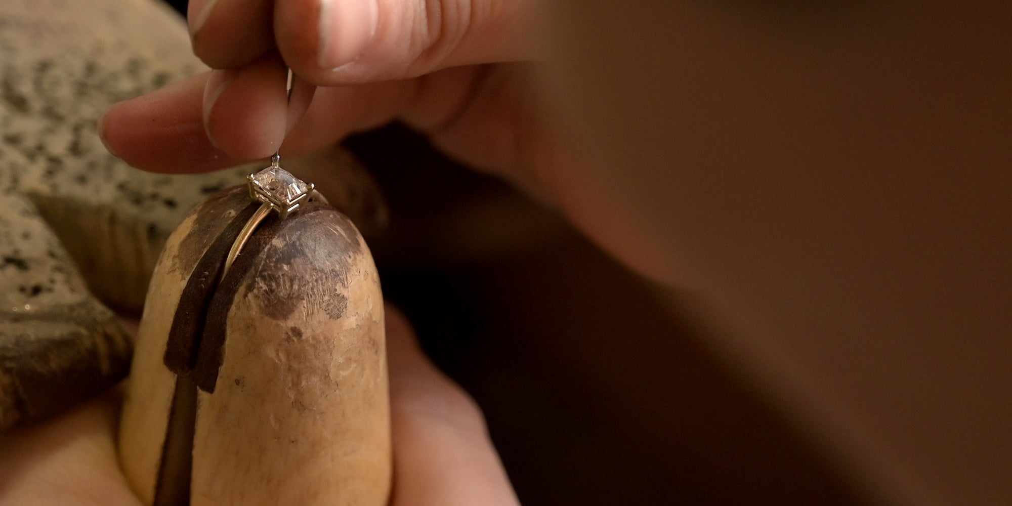 diamond being set using jewellers tools into a bespoke diamond gold engagement ring