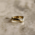 Gold ring on a textured beige surface
