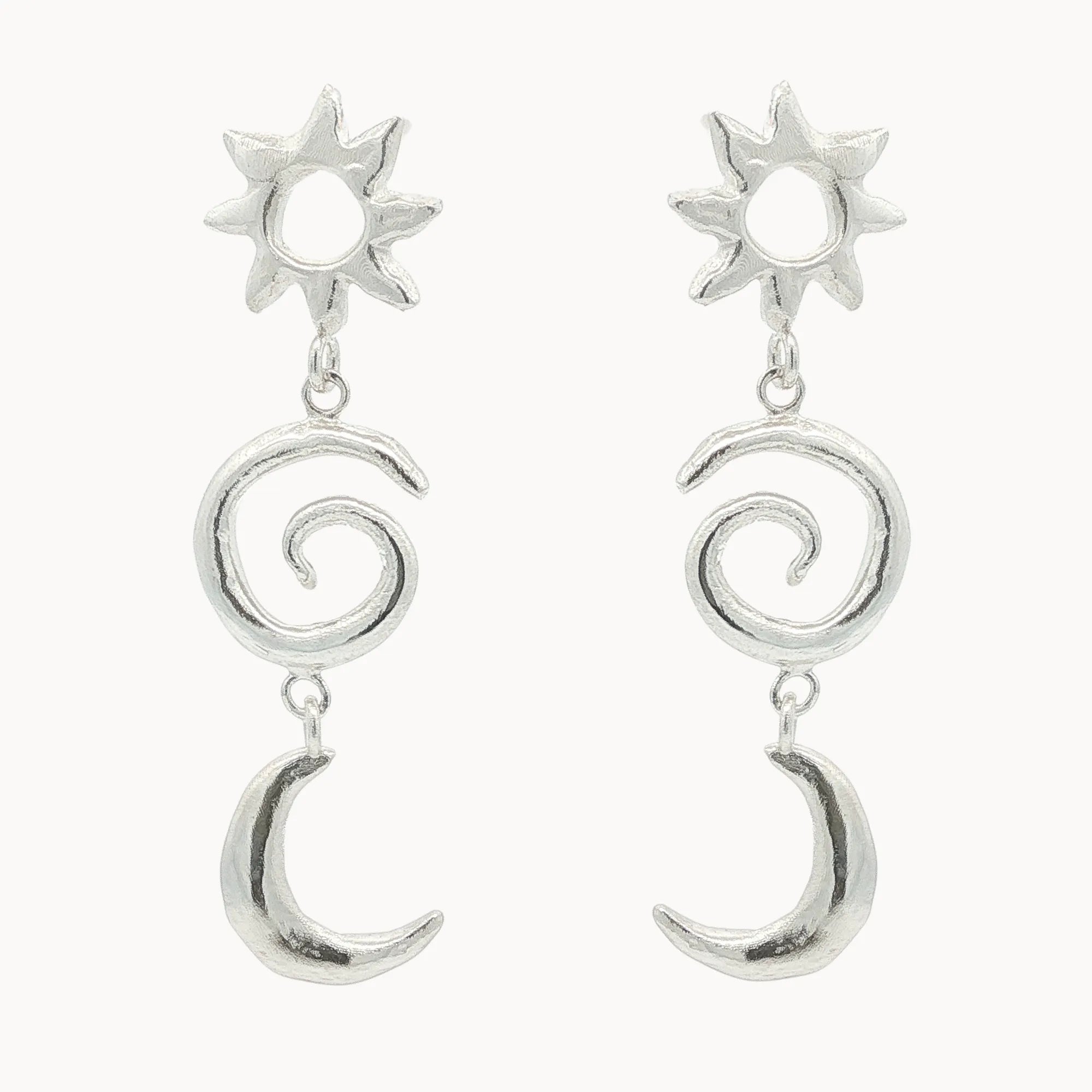 Silver earrings with sun, spiral, and crescent moon designs on a white background