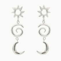 Silver earrings with sun, spiral, and crescent moon designs on a white background