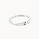 Side view of a silver ring with open top with 'k' and 'j' stamped