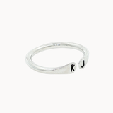 Side view of a silver ring with open top with 'k' and 'j' stamped