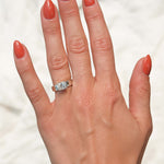Hand with a chunky diamond ring on a white background