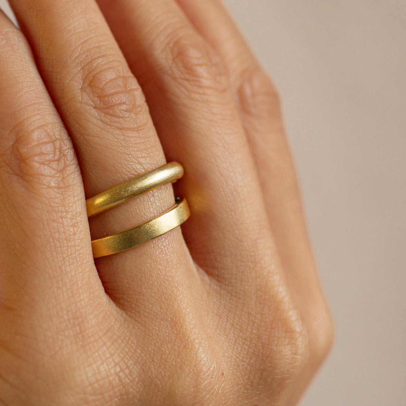 hand with d shaped and flat wedding ring