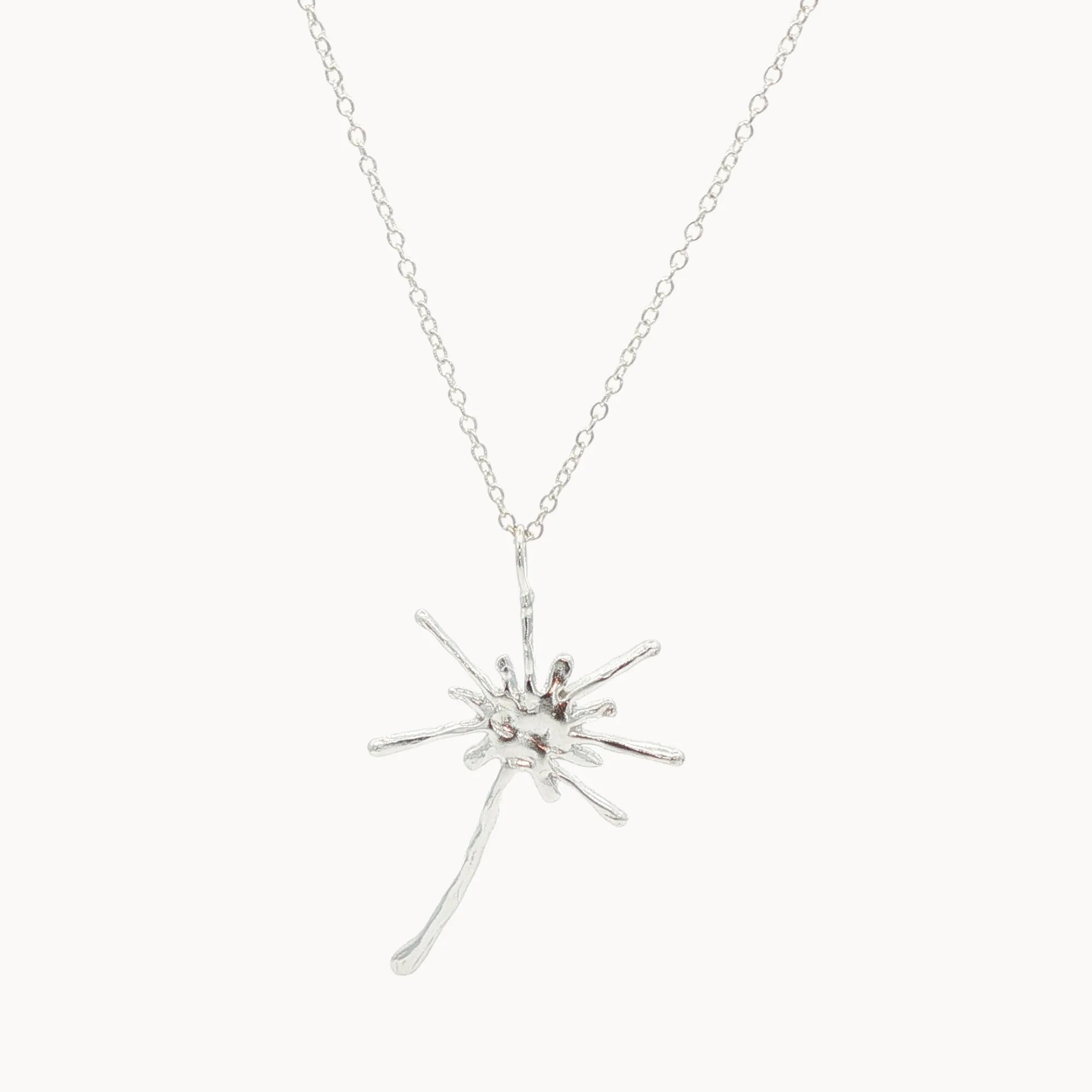 Silver starburst dandelion pendant necklace on a white background