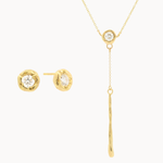 Gold jewelry set with round diamond stud earrings and a y-shaped diamond molten necklace on a white background