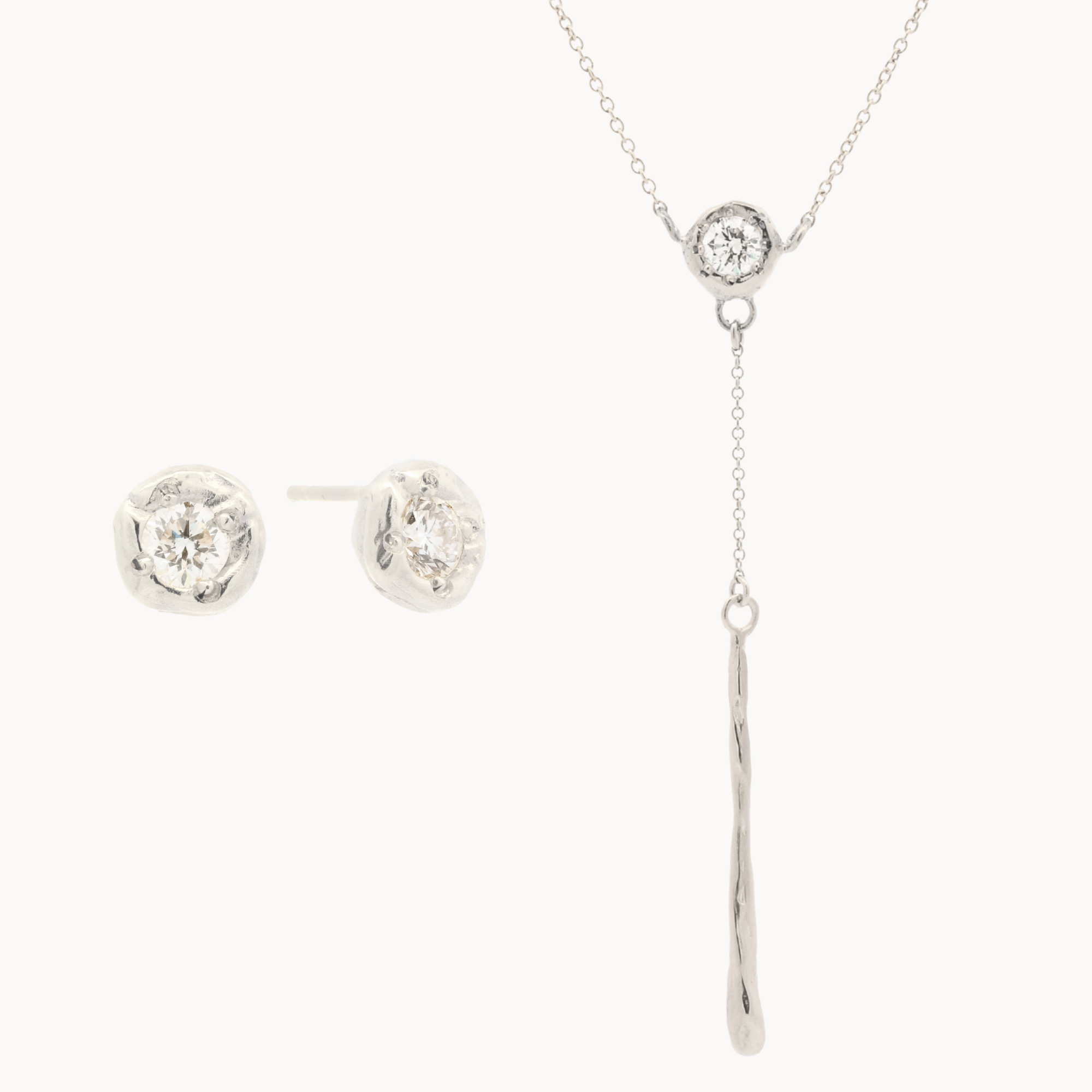 white gold jewelry set with diamond stud earrings and a y-shaped diamond molten necklace on a white background