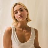 Blonde model wearing scoop neck wedding dress, diamond studs and y-shaped drop diamond necklace
