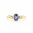 Gold ring with a blue gemstone and two smaller diamonds on a white background